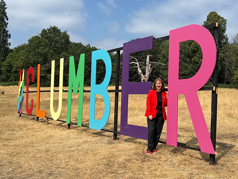 A female stood next to large colourful letter spelling out CLUMBER