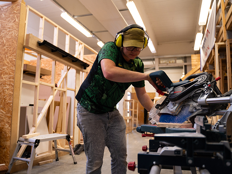 Someone using machinery in the joinery workshop