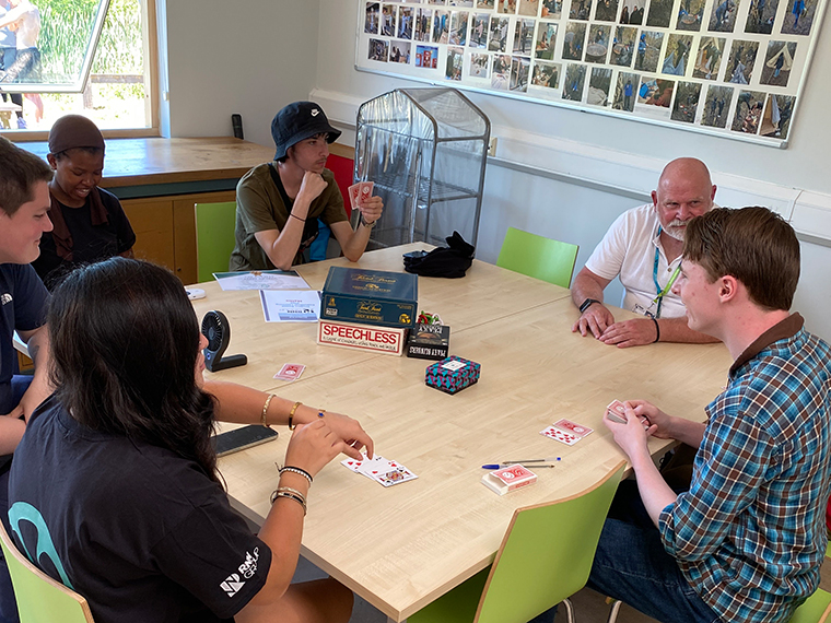 Six people sitting around a table chatting to each other