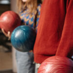 A close up of people holding bowling balls