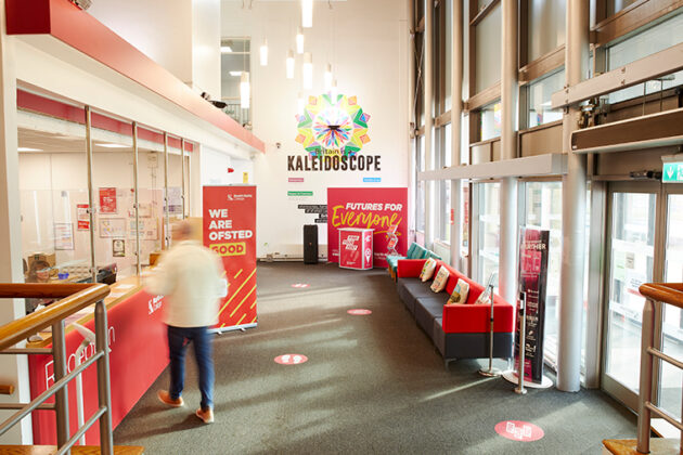 A large reception area with one person walking towards the front desk