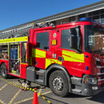 A fire engine with the doors off the sides showing the equipment that it carries