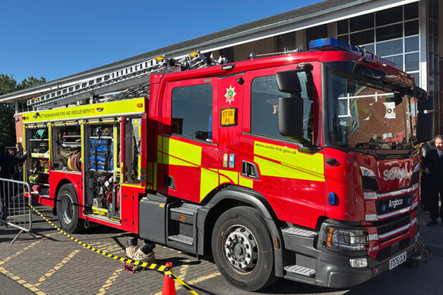 A fire engine with the doors off the sides showing the equipment that it carries