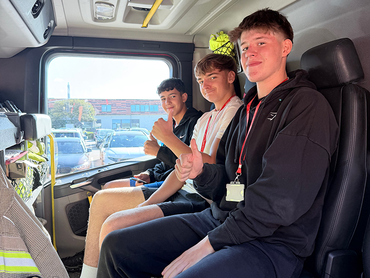 Three students sat in the front seats of a fire engine